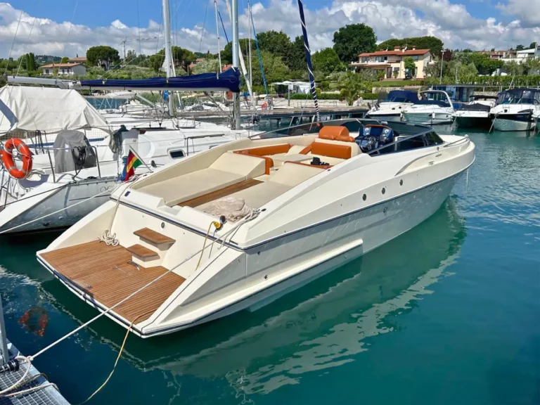 Seitenansicht der Mostes 34 im Hafen, zeigt das elegante Design und das offene Cockpit.