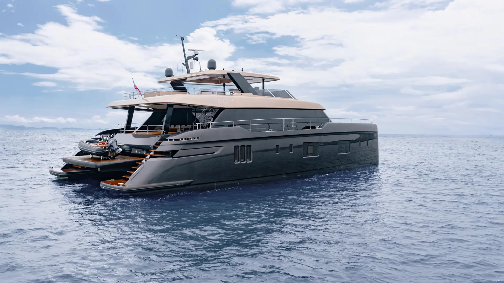 A rear view of the 100 Sunreef Power yacht anchored at sea, highlighting its multi-level design, wide steps leading to the water, and sleek, modern lines.