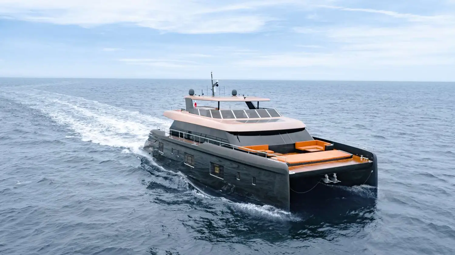 The 100 Sunreef Power yacht cruising through the ocean, with a sleek, modern design, large windows, and a spacious sunbathing area at the front.