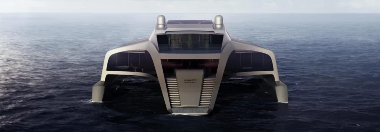 Hinteransicht des 210 Sunreef Power Trimaran bei Tag, auf dem Meer. Die Architektur zeigt eine breite Treppe, die ins Wasser führt, sowie großzügige Fensterfronten, die das luxuriöse Innere des Trimarans erahnen lassen.