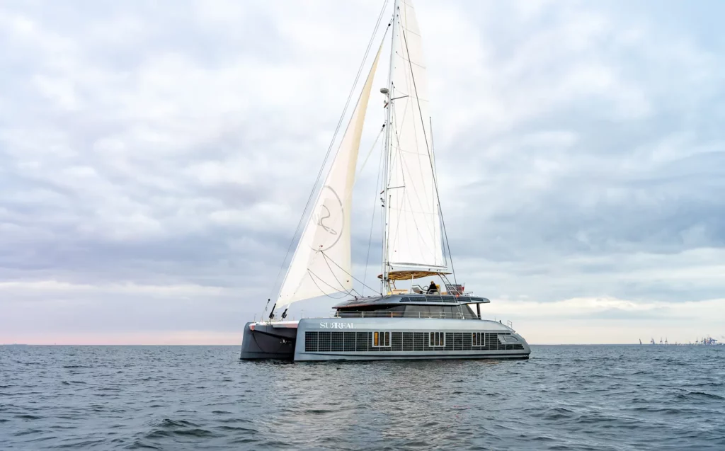 Sunreef 60 auf dem offenen Meer, mit gesetzten Segeln vor einem Hintergrund eines bewölkten Himmels.