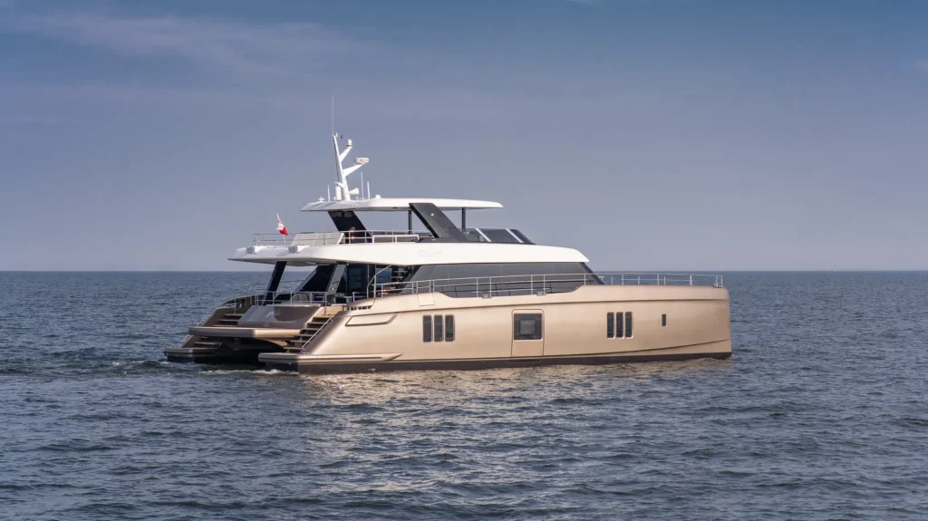 Die 80 Sunreef Power Yacht gleitet elegant über das offene Meer, ihre stilvolle Silhouette und das glatte Deck sind in der Weite des Wassers zu sehen.