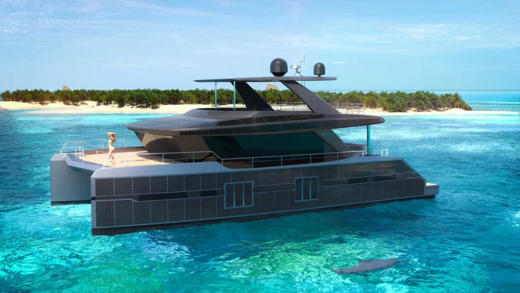 Seitenansicht eines Sunreef Supreme Power Eco-Katamarans, der auf einem ruhigen Meer vor einer Insel fährt, die Solarzellen an den Seiten des Bootes sind deutlich sichtbar.