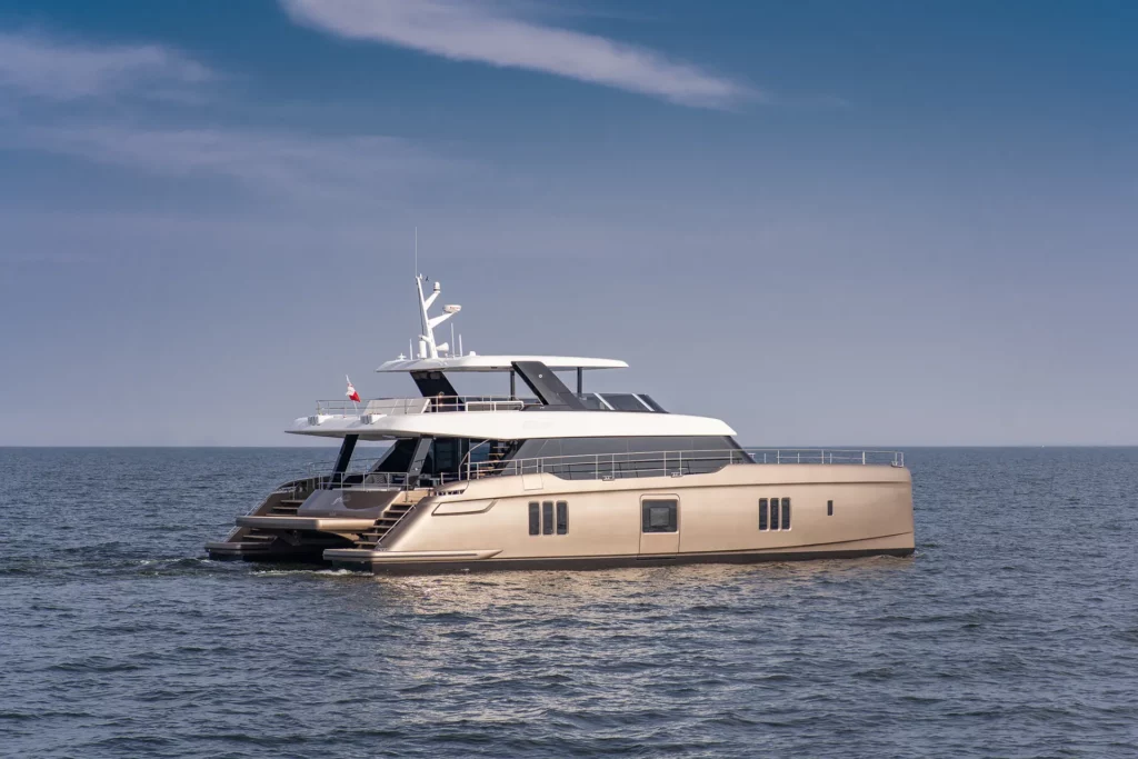 Dieses Bild zeigt eine luxuriöse Sunreef Yachts Power Katamaran, die auf ruhigem Wasser unter einem klaren Himmel fährt. Das schlanke, moderne Design der Yacht betont ihre geräumigen Decks und ihr elegantes, stromlinienförmiges Profil, was sie zu einem Inbegriff von Opulenz und fortschrittlicher Schiffstechnik macht. Diese Yacht verkörpert perfekt das Prestige der Sunreef Yachts Power und bietet eine Mischung aus Komfort, Leistung und Stil auf offener See.